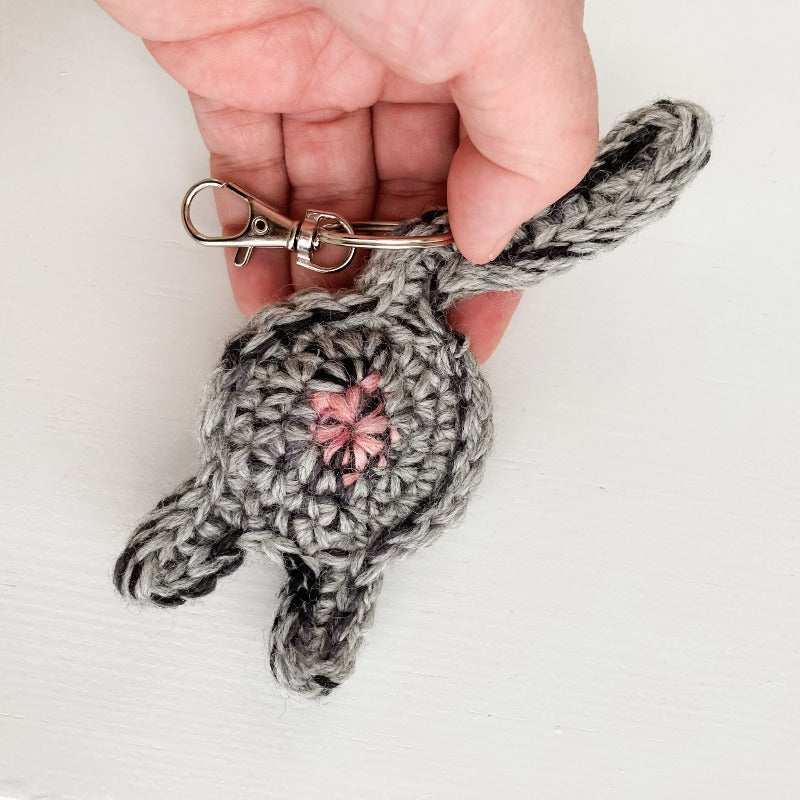 gray tabby cat butt keychain in a hand for scale